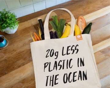 Ein Bild einer Goodbag-Einkaufstasche mit Lebensmitteln darin und einem Design mit dem Text '20g weniger Plastik im Ozean'