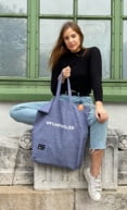 Una donna che tiene una borsa tote goodbag grigia upcycled prodotta con TwoLives